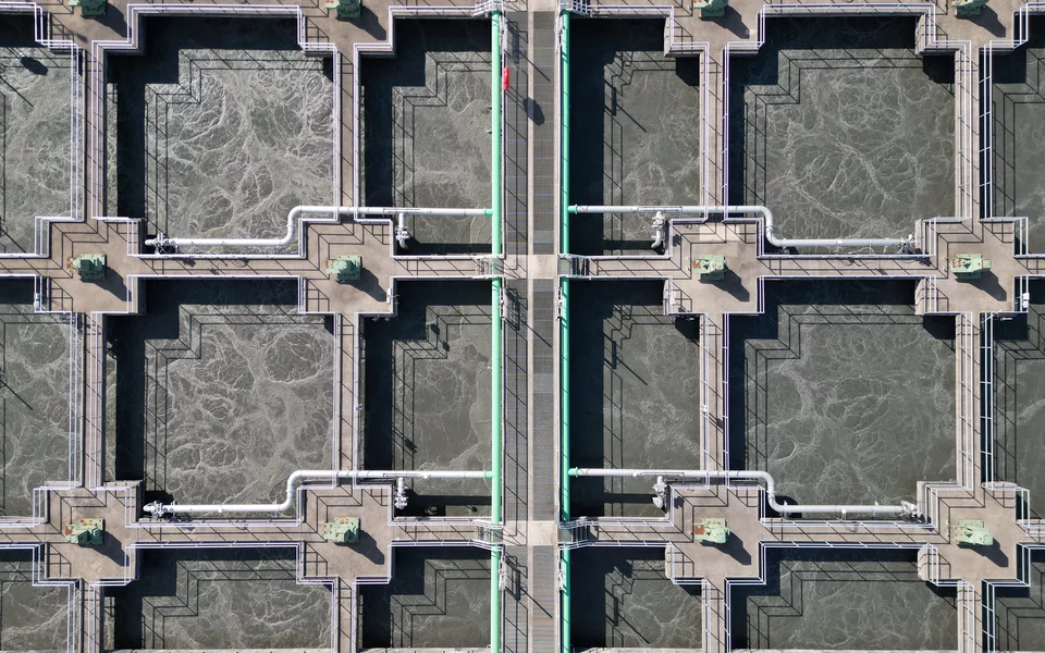 Modern water treatment facility with geometric basins and pipework